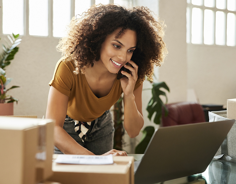 woman on laptop with shipping boxes scattered around