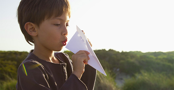 Child holding a paper airplain