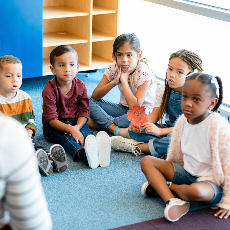 Group of young students sitting on floor.