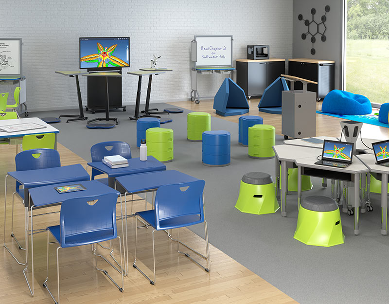 A blue and green modern learning environment with studen desks, a round table with charging station, stools, and several podiums.